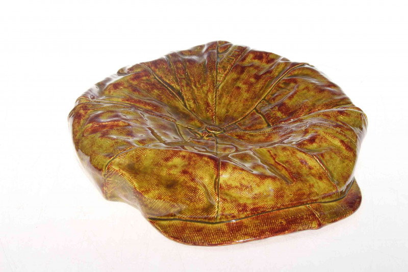 Glazed pottery flat cap, bearing artists monogram.