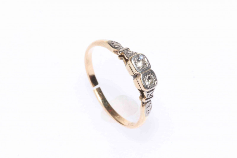 Platinum and 18 carat yellow gold diamond ring featuring two round brilliant cut diamonds, approximate total diamond weight 0.11 carat.