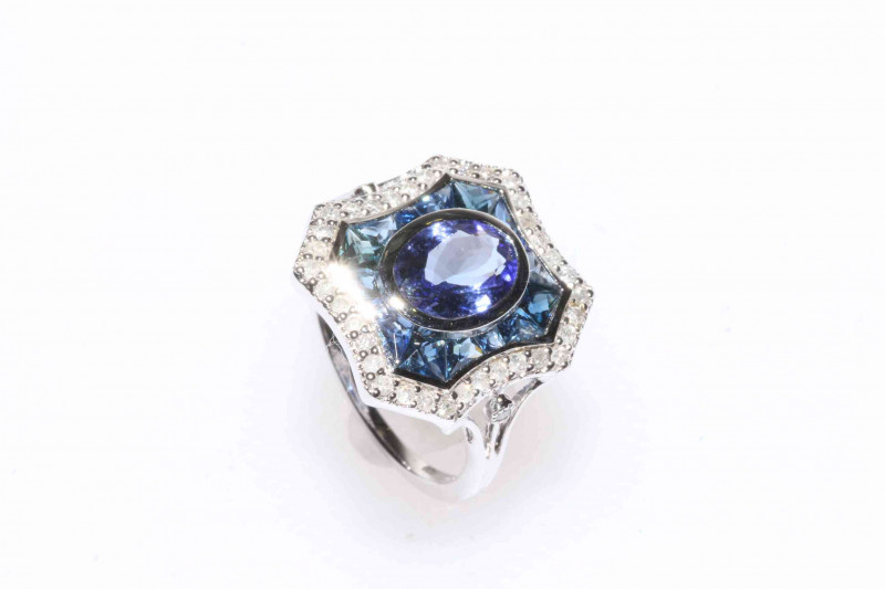 18 carat white gold tanzanite, sapphire and diamond ring featuring one oval cut tanzanite, approximate 1.16 carat with thirty eight round brilliant cut diamonds, approximate total diamond weight 0.25 carat, and sixteen fitted and tapered sapphire, approxi