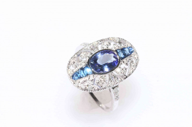18 carat white gold tanzanite, sapphire and diamond ring featuring one oval cut tanzanite, approximate 1.05 carat, with six checker board fancy cut sapphires, approximate 0.24 carats and thirty round brilliant cut diamonds, approximate total diamond weigh