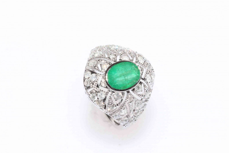 18 carat white gold, emerald and diamond ring, oval cut emerald bezel set, approximate 0.71 carat surrounded by thirty eight round brilliant cut diamonds approximate total diamond weight 0.71 carat.