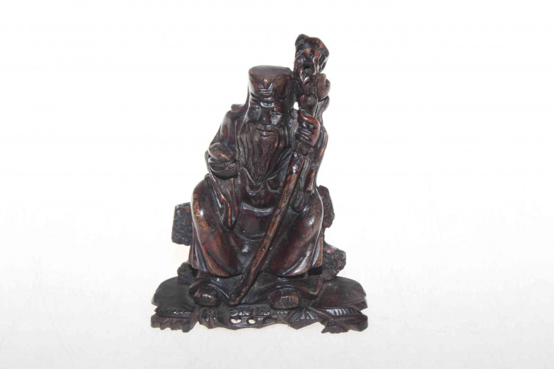 Carved soapstone figure of seated elder on wood base, 16.5cm.