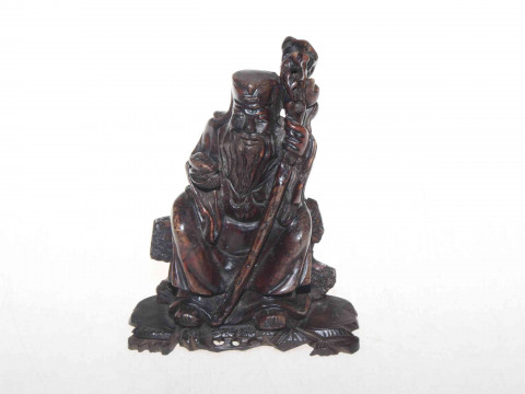 Carved soapstone figure of seated elder on wood base, 16.5cm.