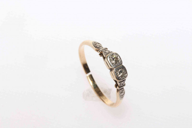 Platinum and 18 carat yellow gold diamond ring featuring two round brilliant cut diamonds, approximate total diamond weight 0.11 carat.