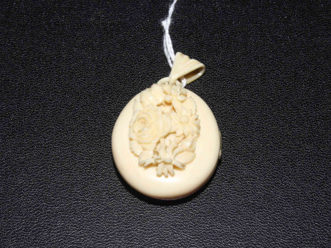 Victorian ivory pendant locket with carved bouquet.