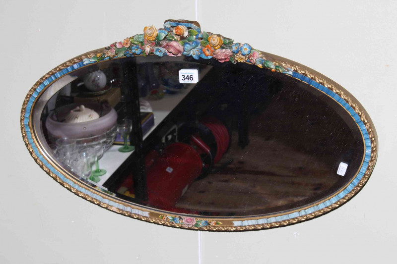 Oval barbola framed bevelled wall mirror.