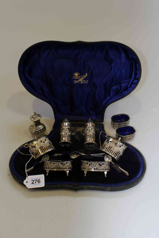 Cased silver six piece cruet set, the bodies pierced and embossed with swags, Chester 1900, together with pair open salts, single pepperette and spoons.