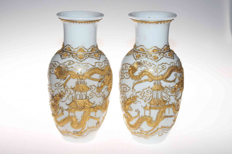 Pair Chinese vases having applied gilt decoration of pagoda and dragons on white ground, 30cm.