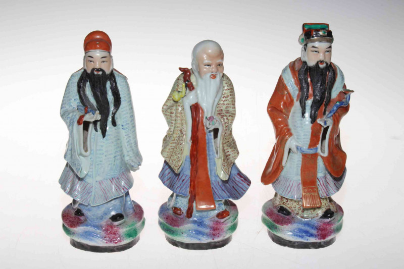 Set of three Chinese polychrome figures of elders, signed inside base, 21/22cm.