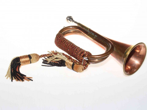 Copper and brass bugle bearing crest and having rope and tassels.