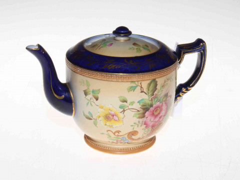 Carlton Ware teapot with flowers on shaded ground.