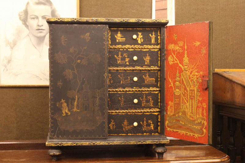 Oriental chinoiserie painted table cabinet having two doors enclosing two short and four long drawers, 56cm by 48cm.