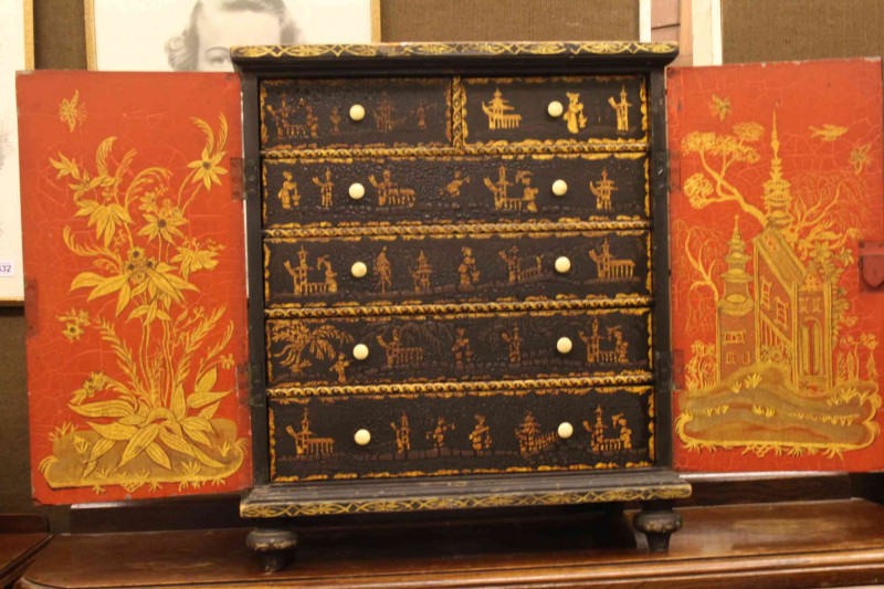 Oriental chinoiserie painted table cabinet having two doors enclosing two short and four long drawers, 56cm by 48cm.