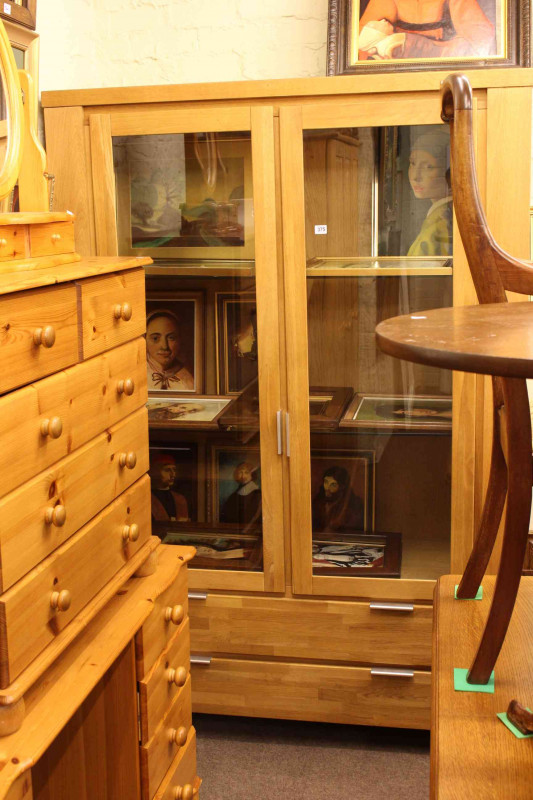 Contemporary light oak display cabinet having two glazed doors above two long drawers, 191cm by 129cm.