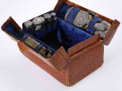 An Edwardian Alligator skin dressing case, with blue silk interior, fitted...