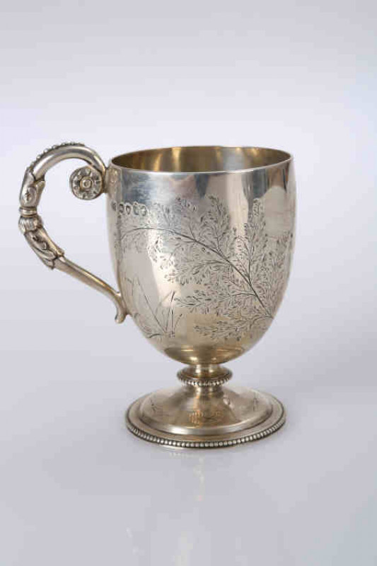 A Victorian silver mug, Thomas Smily, London 1871, the ovoid cup engraved with ferns, monogrammed and dated 1872, raised on a circular foot with ''beaded'' rim. 5.1 troy ozs, 10.5cm