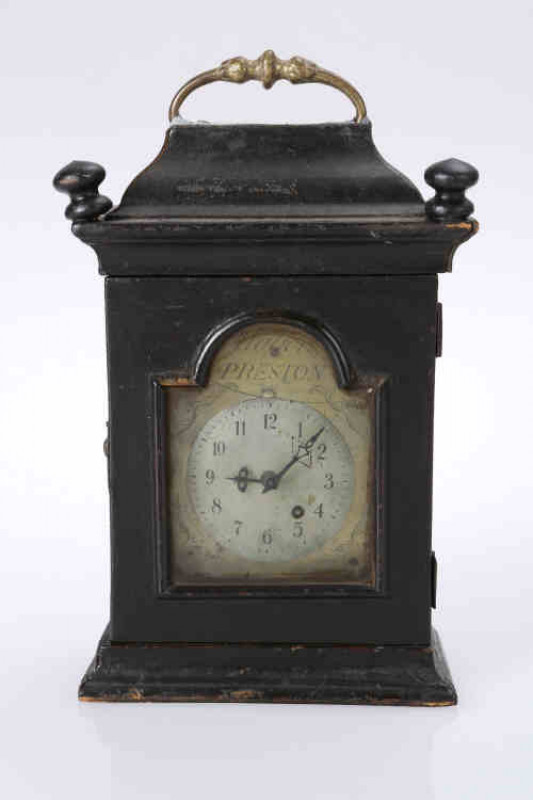 Walker, Preston, a Queen Anne watch clock, c.1710, the 2.75'' brass dial, signed in the arch, with steel face with Arabic numerals, rod pendulum, in an ebonised case with caddied top and brass carrying handle. 20cm