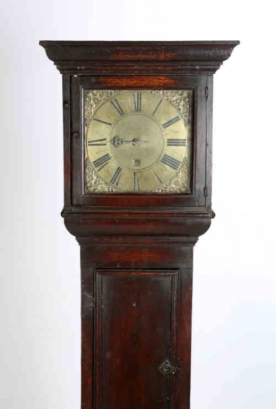 John Andrews, London, an oak cased thirty hour single pointer longcase clock, the 11'' square brass dial with date aperture, the four corners applied with spandrels depicting putti holding aloft a crown, the hood with projecting cornice, the c