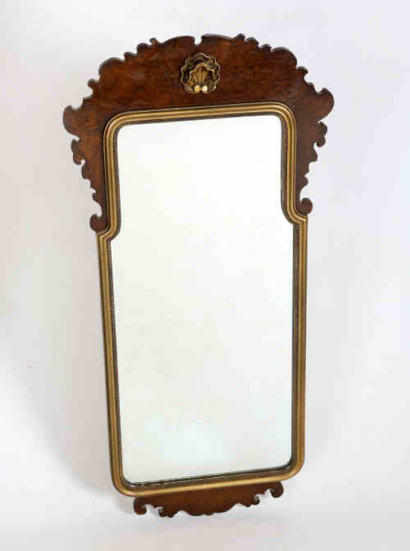A George II style burr walnut fretwork mirror, early 20th century, the shaped rectangular mirror plate within a gilt slip, below a shaped crest centred by a carved and gilded shell. 1.00m