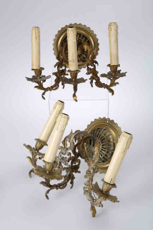 A pair of Rococo Revival gilt-brass three light wall sconces, each pierced and ''beaded'' circular backplate issuing acanthus cast scrolling arms.