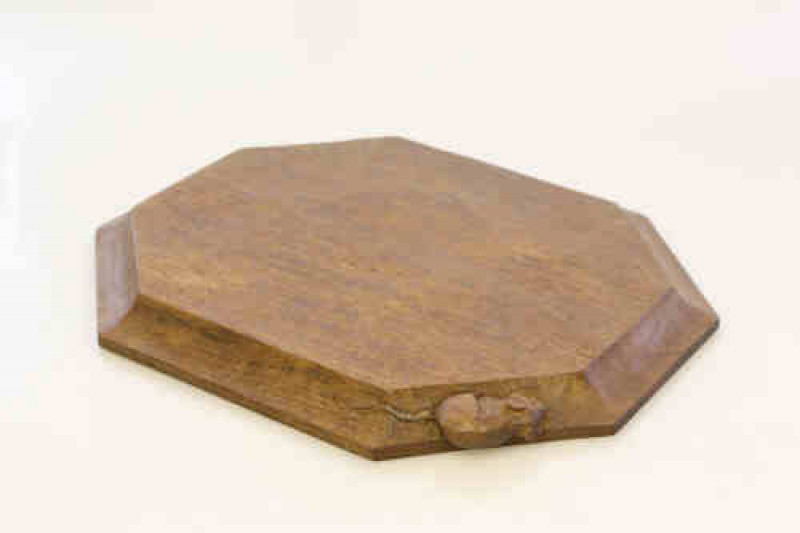 A Robert ''Mouseman'' Thompson oak breadboard, of characteristic form, adzed, with carved mouse signature. 31cm by 25cm