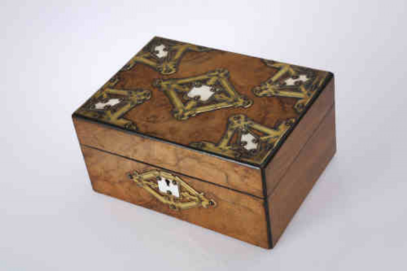 A Victorian burr walnut and brass box, the rectangular lid applied with ''Gothic'' brass strapwork mounts centred by ivory plaques. 13cm by 27cm by 20cm