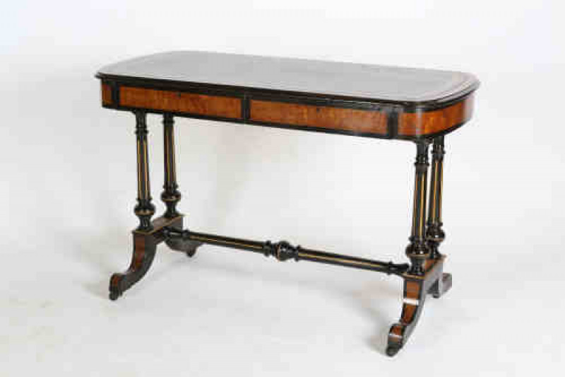 A 19th century burr walnut, ebonised and parcel-gilt library writing table, the moulded rectangular top, with bowed ends, enclosing a leather writing surface with gilt tooled Greek Key band, over a pair of crossbanded frieze drawers, raised on two pairs o