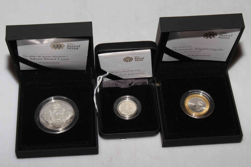 Three silver proof Royal Mint coins in boxes with COAs. Including 2008 £1, 2008 £5 UK Queen Elizabeth I and 2010 £2 Florence Nightingale.