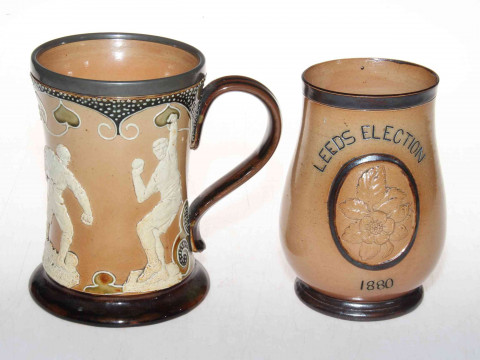 Doulton Lambeth stoneware 'sporting' mug with relief decoration, 15cm, together with Gladstone Leeds Election 1880 baluster beaker (2). thumbnail