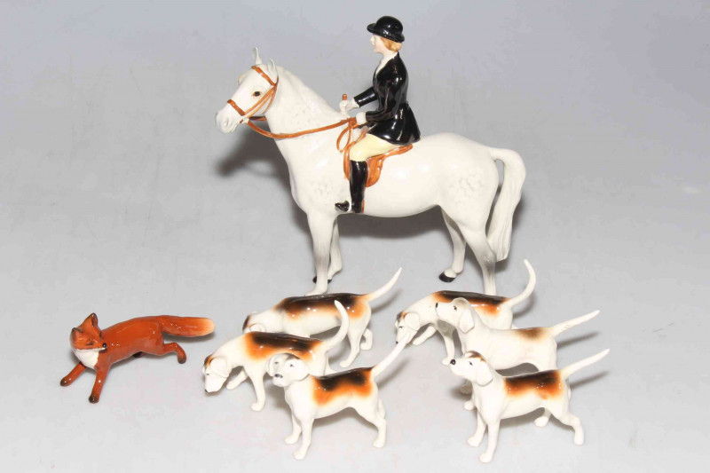 Beswick Huntswoman on grey with six hounds and fox.