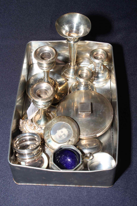 Box of fourteen small silver items including Victorian pocket watch, engine-turned powder bowl, napkin rings, decanter labels, photograph frame, candlesticks, etc.