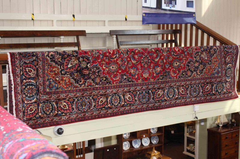 Large hand made Iranian red ground carpet from the Mashad region, 395 by 290cm.