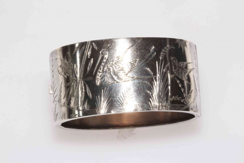 Silver hinged bangle with engraved decoration of birds, butterfly and water plants, 31mm wide.