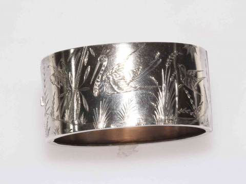 Silver hinged bangle with engraved decoration of birds, butterfly and...