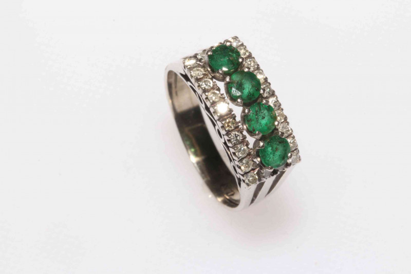 Emerald and diamond cluster 14k white gold ring, having four emerald row border with 24 brilliant cut diamonds, size Q.
