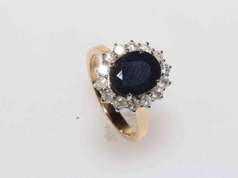 Sapphire and diamond 18 carat gold cluster ring, having oval 4 carat sapphire...