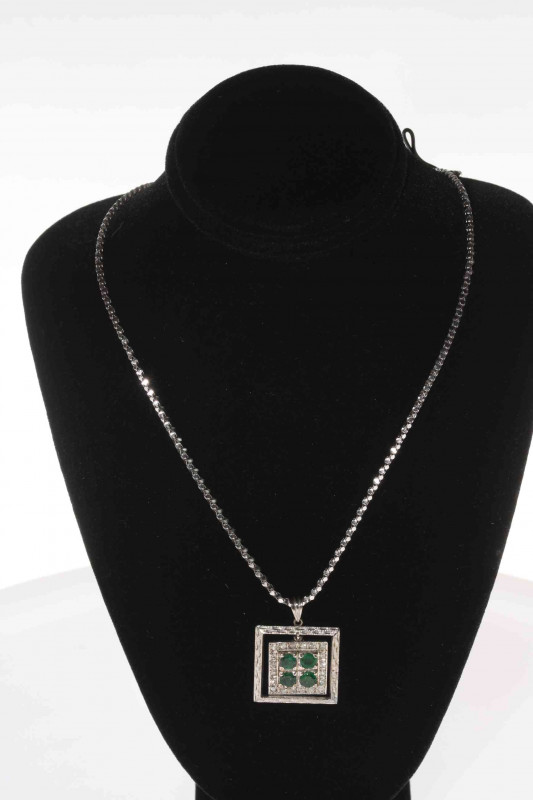 18 carat white gold, emerald and diamond pendant, with four emeralds and twenty small diamonds, 2.1cm square, with 18 carat white gold chain.