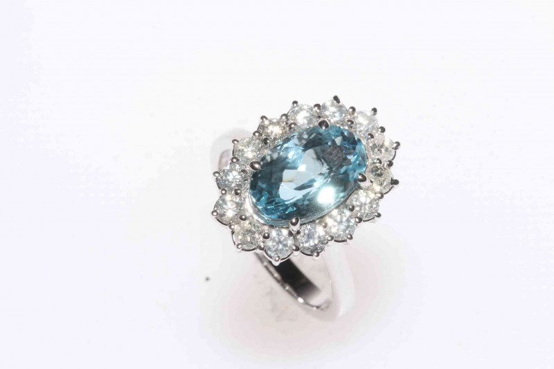 18 carat white gold, blue topaz and diamond cluster ring, having 8 carat oval blue topaz, size N.