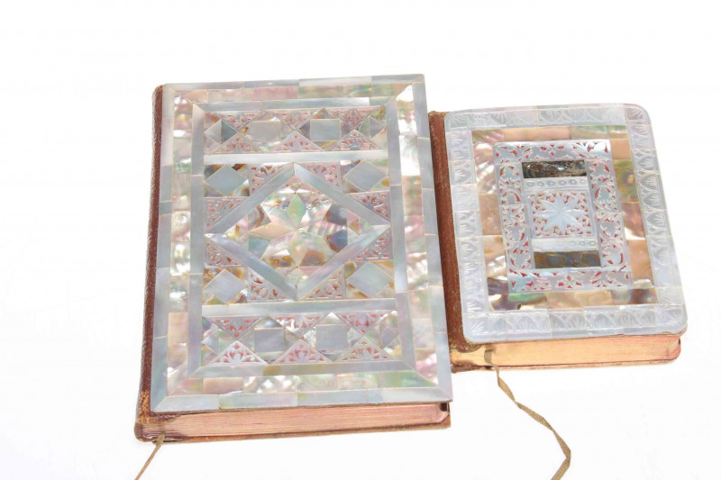 Two ornate mother of pearl veneered New Testament books, largest 16cm by 11cm.
