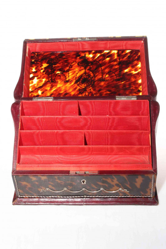 Good silver inlaid tortoiseshell stationery box, the sloping lid inlaid with garlands and revealing fitted interior, 29cm wide, 20cm high.