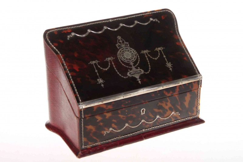 Good silver inlaid tortoiseshell stationery box, the sloping lid inlaid with garlands and revealing fitted interior, 29cm wide, 20cm high.