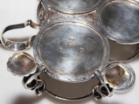 George III silver Warwick three bottle cruet on shell feet, makers mark R.P (R. Peaston) London 1766, with three bottles having matching crest, the frame with good hallmark to base, 17cm across. thumbnail
