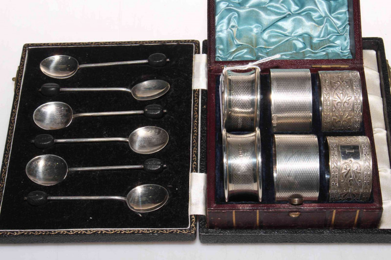 Case set of six silver coffee bean handle spoons, two pair of engine-turned silver napkin rings and EP pair, with case.