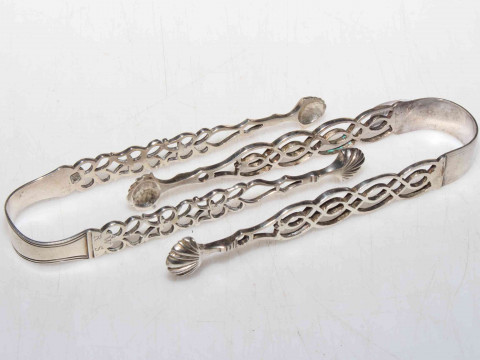 Two pair of silver sugar tongs with fretwork arms and shell design bowls.