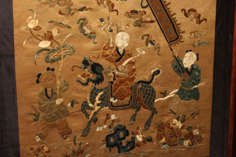 Framed Chinese silkwork depicting a Gentleman Riding a Dragon with Two Figures on Foot, in glazed frame, 49.5cm by 47.5cm including frame.