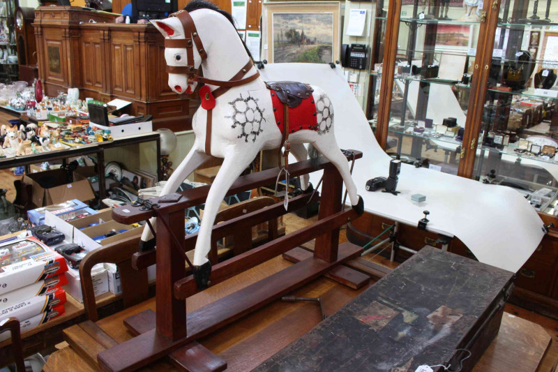Small sponge painted rocking horse on stained safety stand, 93cm by 111cm.