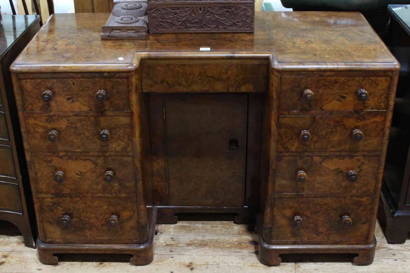 Figured walnut inverted breakfront nine drawer pedestal desk with kneehole cupboard door, 77cm x 120cm x 55cm.