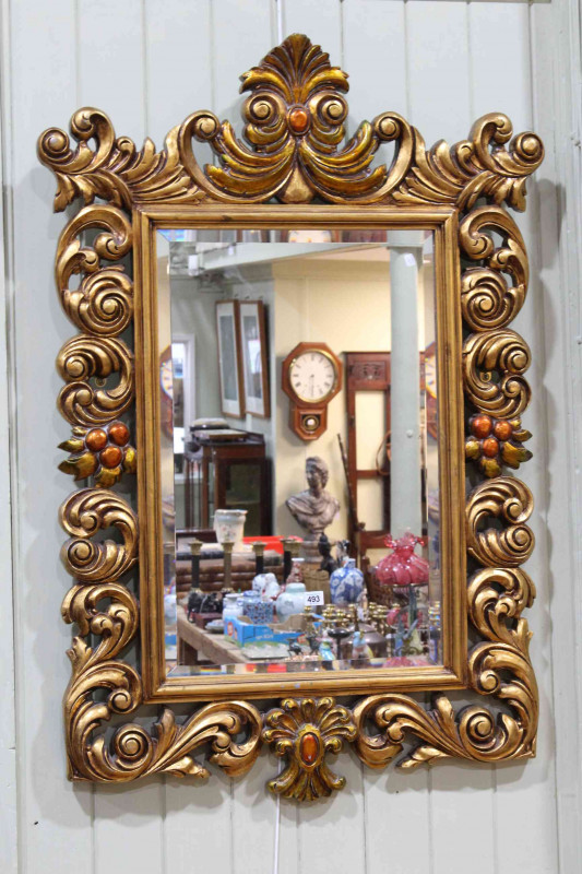 Ornate gilt framed bevelled wall mirror, 124cm x 84cm overall.