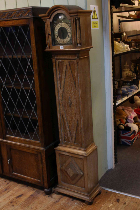 Limed oak grandmother clock having arched brass dial.