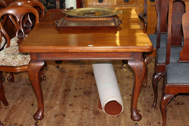Mahogany extending dining table, leaf and winder, raised on cabriole legs, 74cm x 104cm x 144cm (including leaf).